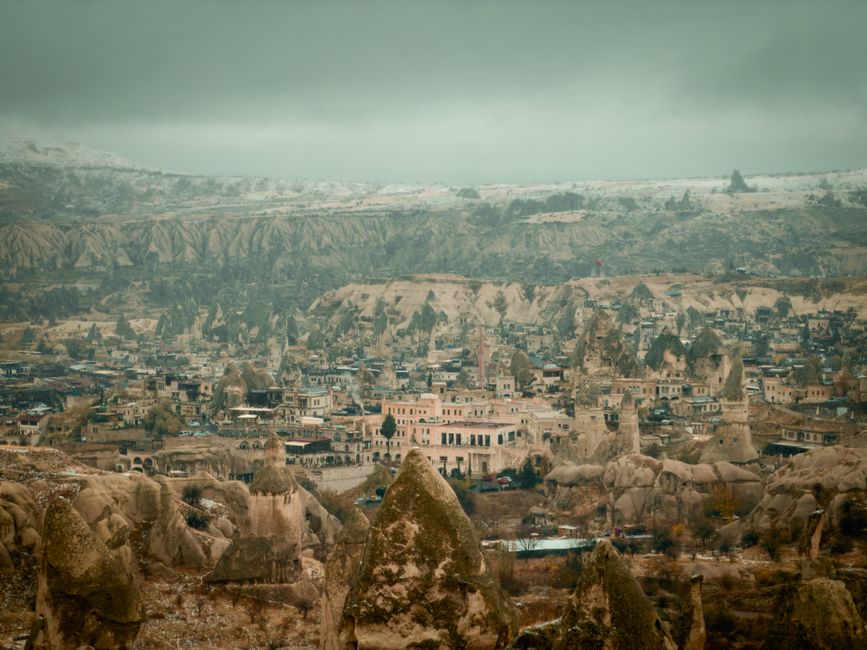 A panoramic view of Cappadocia's distinctive landscape with rock formations and a historic town.